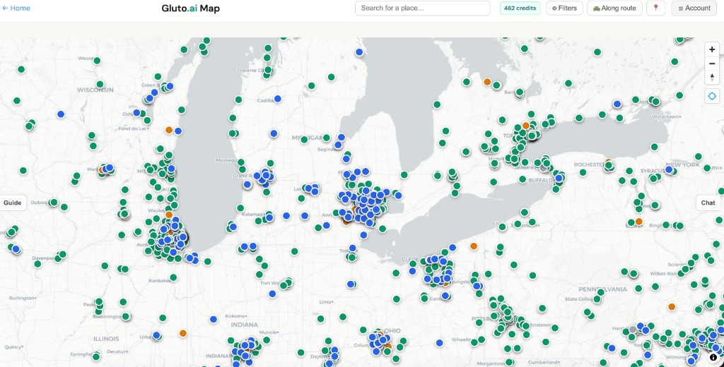 Gluto.ai Map spanning Great Lakes states with dense blue, green, and orange pins; toolbar with Search for a place, credits, Filters, Along route; Guide tab on left and Chat tab on right